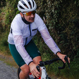 Cyclist on a road surrounded by greenery