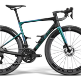 A high-end road bicycle with a dark teal and black carbon fiber frame, black drop handlebars, and deep carbon fiber wheels, shown from a side profile on a white background with a soft shadow.