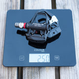 Bicycle pedal on a digital scale with 'Favero' branding on a wooden surface