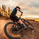 Person riding a mountain bike on a dirt trail with a scenic background