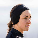 A person wearing a black Tineli Core Winter Headband, designed for cold-weather protection while engaging in outdoor activities.
