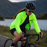 Female cyclist cycling on a road with a scenic background
