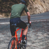Cyclist on an orange bicycle on a mountain road