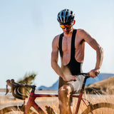 Man on a bicycle in a desert setting with clear sky