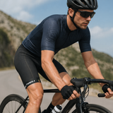 Cyclist on a mountain road wearing a helmet and sunglasses.