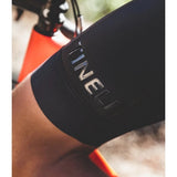Close-up of a black glove with 'TINELLI' branding on a blurred background