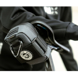 Gray riding glove with a brand logo on a blurred background
